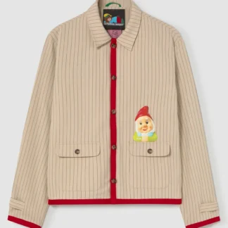 The Secret Gnome Society Jacket is a beige, pinstriped piece with red trim, brown buttons, a smiling cartoon gnome patch on the left pocket, classic collar, and two front pockets—showcasing playful Estonian design. Gate21.ee