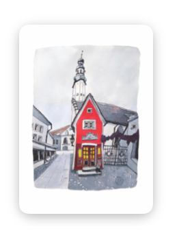 A Wisdom / Old Town Tea-towel - KÕIK features a small red building with yellow windows on a quiet street, set against a tall white church tower and cloudy sky. Gate21.ee