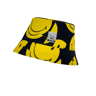 The Smiley - Bucket Hat is black with large yellow smiley face graphics and a white rectangular label on the front, displayed against a plain white background. Gate21.ee