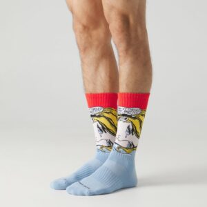 A person wearing light blue Roy Lichtenstein Hopeless - Athletic socks with a pop art illustration of a woman's face and speech bubble, standing on a plain light background. Gate21.ee