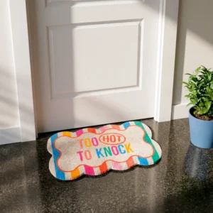 The Doormat - "Too hot to knock" features a bone shape with colourful edges and bold text, placed before a white door. A green potted plant in a blue pot sits to the right. Ideal for pairing with a handheld fan on hot summer days. Gate21.ee