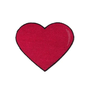 The "Heart" Doormat is a red, heart-shaped mat with a black outline, pictured on a white background, bringing to mind the cool relief of a fan on hot summer days. Gate21.ee