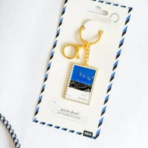 The Võtmehoidja – Talvine mets is a gold keyring with a rectangular winter forest pendant labelled Estonia, attached to an airmail-style card reading “Winter forest” and “Soft enamel keyring”—perfect for your New Rebels small rucksack. Gate21.ee