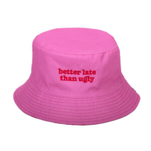 The Reversible Bucket Hat - "Better Late Than Ugly" features bright pink fabric with red embroidered text on the front—a stylish summer accessory perfect for outings or pairing with a fan. Shown on a plain white background. Gate21.ee