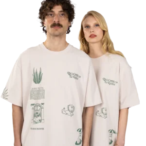A man and a woman stand side by side wearing matching Moomin Heavy Ts - Lavender, both featuring green illustrated designs and "Moomin on the Riviera" text, looking straight at the camera. Gate21.ee