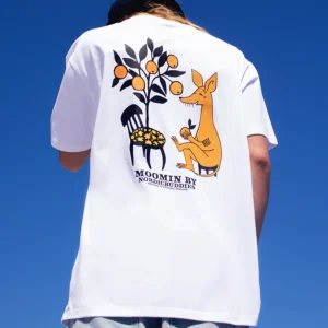 A person wears the white Moomin Heavy Ts - Sniff T-shirt, which features a colourful back illustration of Sniff on a stool next to a chair and an orange tree, with the text "MOOMIN BY NORDBUDDIES. Gate21.ee