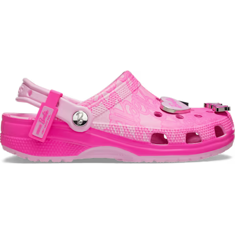 The Crocs Barbie® Classic Clog features a pink and light pink gradient colour design, ventilation holes, a back strap, and decorative charms on the upper. The shoe is finished with a textured sole. Gate21.ee