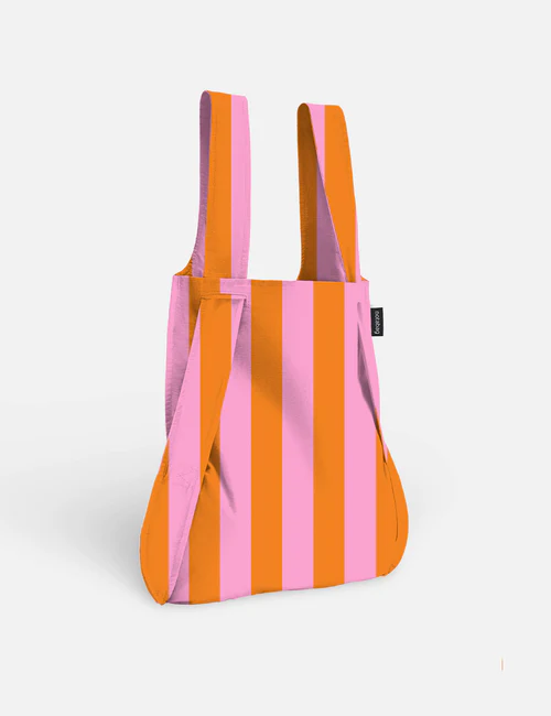 The Playground - Special Edition (Copy) reusable Notabag, featuring wide vertical stripes in orange and pink, two handles, and a small black label on the side, is displayed against a plain white background. Gate21.ee