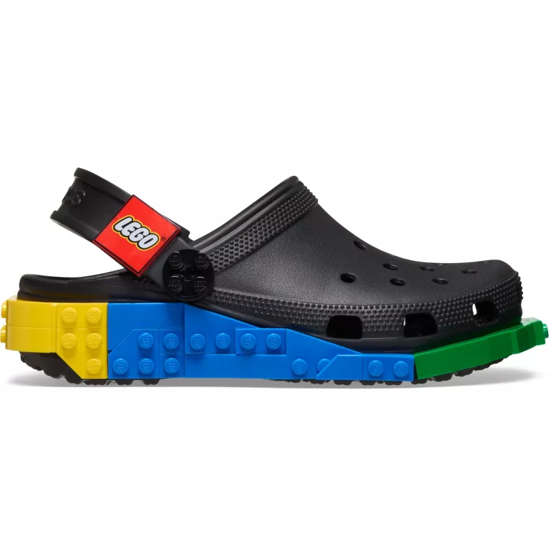 The Crocs™ 4LW System Clog in black showcases vibrant LEGO brick patterns across the midsole and a red LEGO logo on its adjustable heel strap, with yellow, blue, and green accent panels completing the colourful design. Gate21.ee