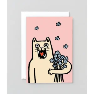 A cartoon cat with wide eyes and an open mouth holds a bouquet of blue flowers against a pink background, perfectly capturing the playful charm of the “I Love you Cat!” - Greeting Card. Small blue flowers are scattered in the air, whilst a white envelope is partially visible behind the card. Gate21.ee