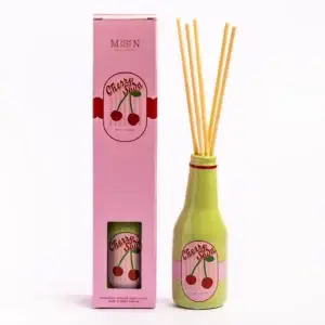 A pink box labelled Cherry Soda stands next to a green bottle with the same label. The bottle contains several reed diffuser sticks. Both items are set against a plain white background. Gate21.ee