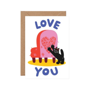 The “Love You! - Greeting Card” features the words LOVE YOU, a pink armchair with scratch marks, and a black cat scratching the chair. The card is displayed with a brown envelope in the background. Gate21.ee