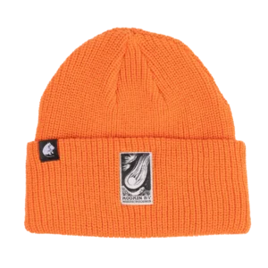 The Moomin Beanie - Orange is a bright orange knitted beanie with a turned-up brim. It features a black patch with a white illustration on the front and a smaller black tag with a character silhouette on the side, evoking designs similar to those found on Moomin keyrings. The background is white. Gate21.ee