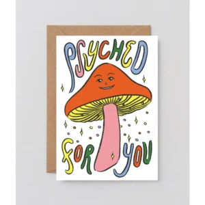 The “Psyched! - Greeting Card” features a smiling cartoon mushroom with a pink stem and orange cap, colourful “Psyched for you” text, and comes with a brown envelope. Gate21.ee