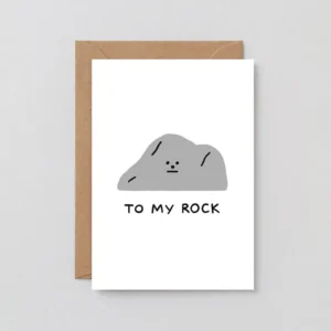 The Rock! - Greeting Card features a simple grey rock with a face and “TO MY ROCK” text, displayed on a brown envelope against a plain background. Gate21.ee