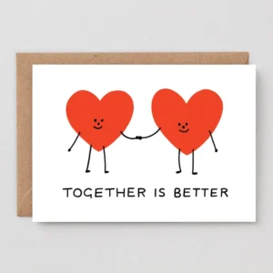 Two red heart-shaped characters with smiling faces hold hands above “TOGETHER IS BETTER” on the Together! - Greeting Card, shown with a white wrap and brown envelope. Gate21.ee