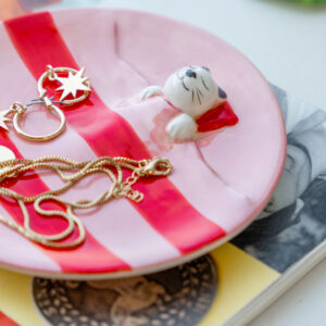 Loving Cat - Jewellery Plate ceramic dish with pink and white stripes, featuring a small sculpted cat in the centre and gold jewellery resting on its surface. Gate21.ee